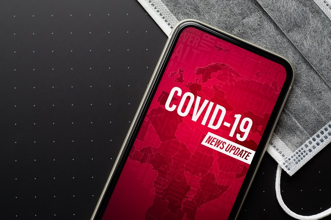 Cell phone with a background map and the words, "Covid-19, news update"
