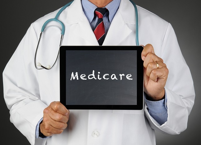 Doctor holding an electronic tablet that says "Medicare"