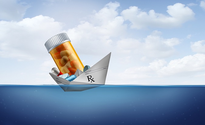 A bottle of prescription pills in a paper boat made out of a prescription form, floating on water